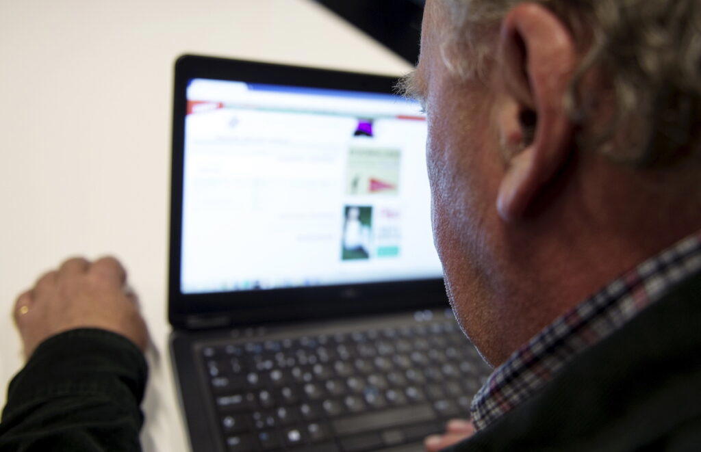 En man surfar på webben. Avanza använder aldrig Whatsapp och uppmanar dig att bara lita på deras officiella kanaler, för att vara helt säker på att det är Avanza uppmanar nätbanken dig att enbart följa deras officiella konton som du hittar på deras webbplats.