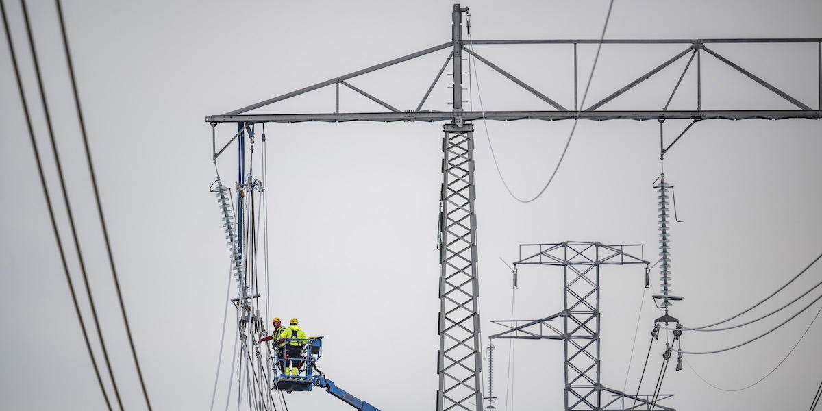 Montörer i arbete med att dra nya 400 kVolt högspänningskablar i ledningsstolpar. I höst ser vi ut att få dras med högt elpris.