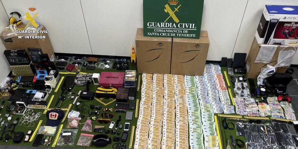 Föremål som stals ur resenärers väskor på Teneriffas södra flygplats visas upp av Guardia Civil efter gripanden i december 2023. Fjorton anställda greps misstänkta för stölder till ett värde av nära två miljoner euro. (Foto: Guardia Civil / AP/TT)