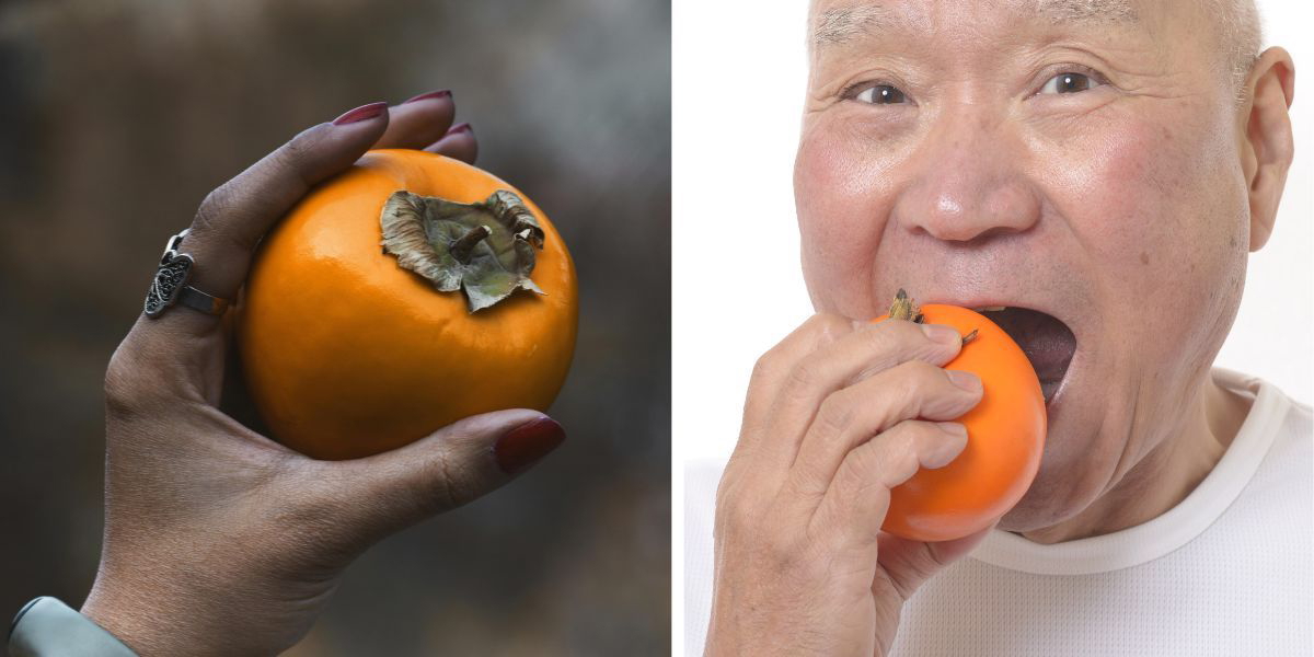 En kvinnas hand håller i en persimon och en man äter en persimon