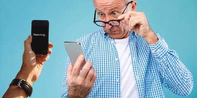 En mobiltelefon söker sitt nät och en man tittar förvånat på sin mobil