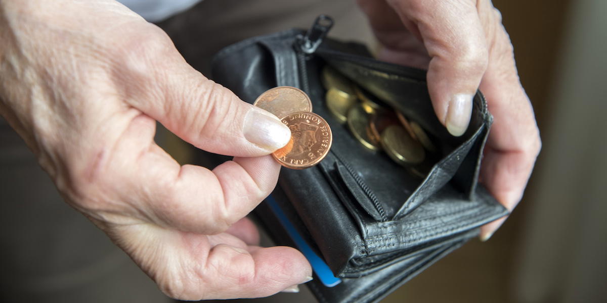 Pensionär med plånbok och mynt. Många pensionärer har svårt att få pengarna att räcka när alla räkningar ska betalas, men den gas i pensionssystemet som pensionsguppen föreslår ger bara fyra kronor mer i månaden för en genomsnittspensionär år 2027