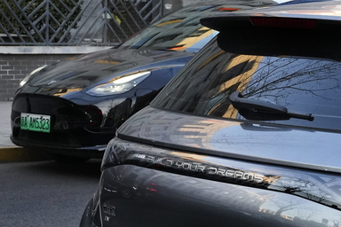 En Tesla och en BYD parkerade i Peking. Arkivbild.