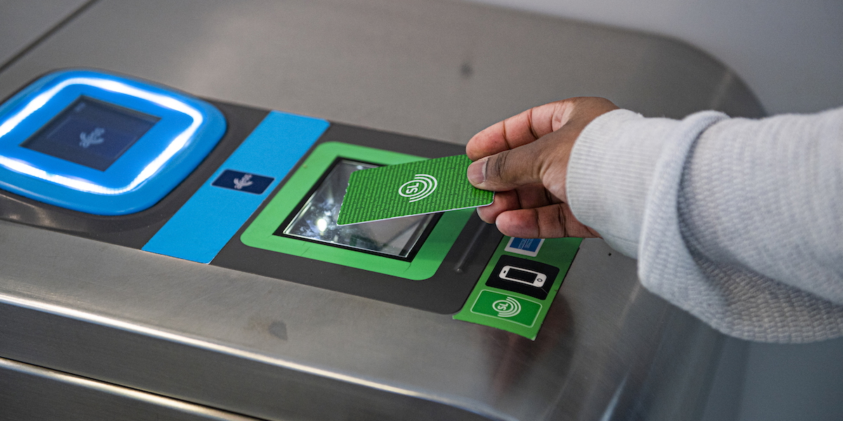 En person "blippar" ett grönt SL-kort vid en tunnelbanespärr. SL-kortet som ger tillgång till hela länets kollektivtrafik är billigt i jämförelse med kostnaden för kollektivtrafiken i övriga landet.