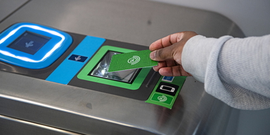 En person "blippar" ett grönt SL-kort vid en tunnelbanespärr. SL-kortet som ger tillgång till hela länets kollektivtrafik är billigt i jämförelse med kostnaden för kollektivtrafiken i övriga landet.