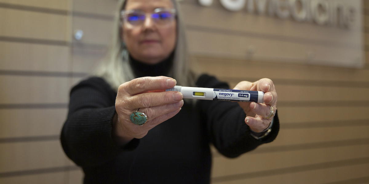 En kvinna håller fram en injektionspenna med Wegovy, Novo Nordisks läkemedel för viktminskning. Apotek Hjärtat varnar nu för ovetenskapliga råd om de nya läkemedlen för viktminskning som sprids i sociala medier.