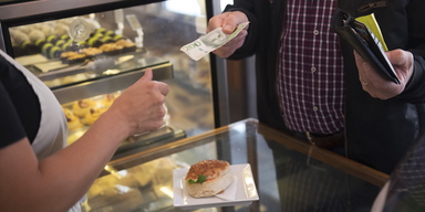 En man betalar med kontanter i butik.