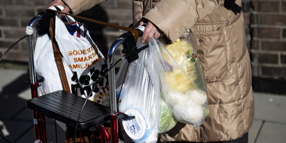En pensionär med rullator går med enkla matkassar längs en gångväg i Södertälje. Tusentals medlemmar i Pensionärernas riksorganisation, PRO, har gått ut och handlat i matvarubutiker runt om i landet för att ta reda på vilken matkedja som är billigast. i årets prisundersökning.