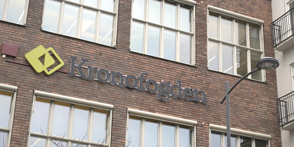 Kronofogdens logga på en fastighet med tegelfasad i Sundbybergs centrum.