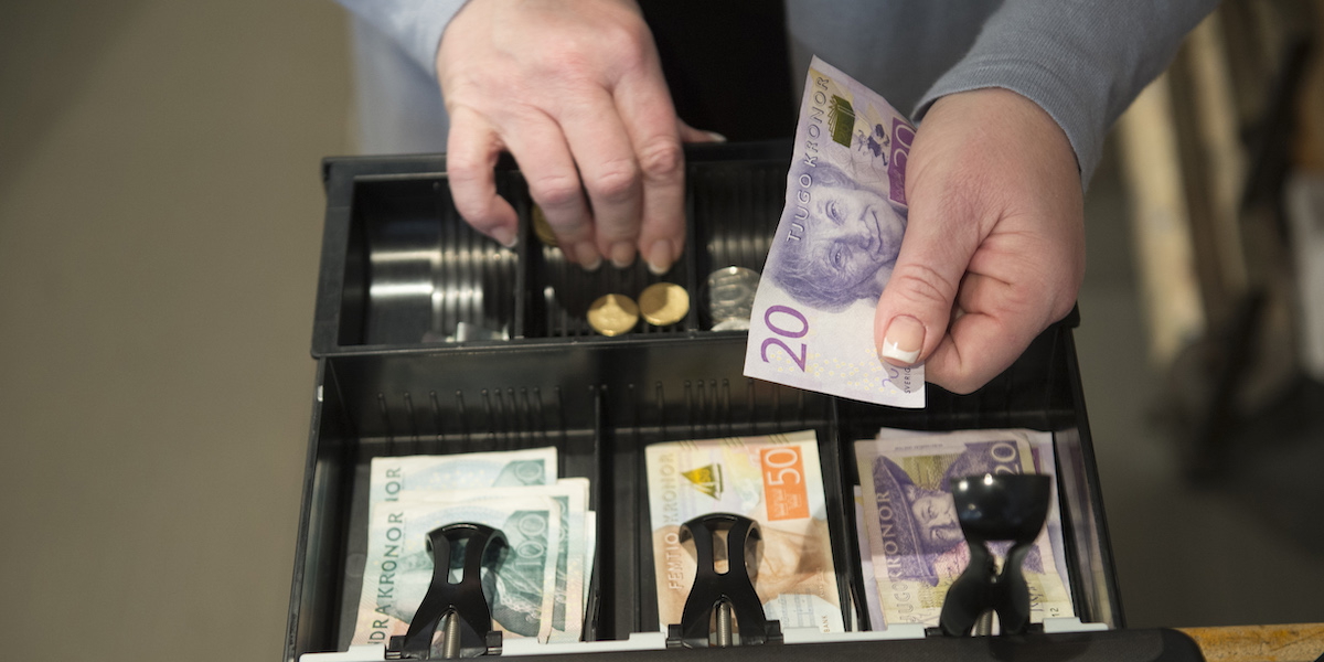 Kontanthantering i kassan i en butik. Från och med den 1 juli måste bemannade butiker ta emot kontanter enligt en lagrådsremiss från Finansdepartementet.
