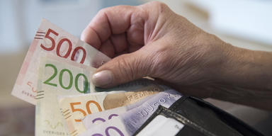 Pensionär med plånbok och sedlar.