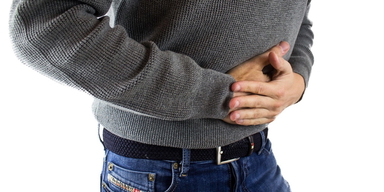 En man har ont i magen. En ny studie visar att var du bor kan påverka bakterierna i din tarm och därmed i förlängningen även hur du mår.