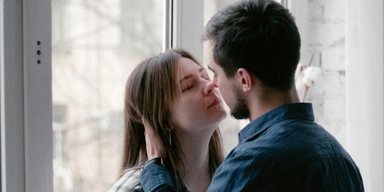 Ett ungt par framför ett fönster. Enligt en studie lever män i parrelationer i genomsnitt fem år längre om de gör det här på morgonen.