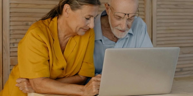 Ett par sitter med en bärbar dator. De flesta, 55 procent, som får skatteåterbäring planerar att spara eller investera den.