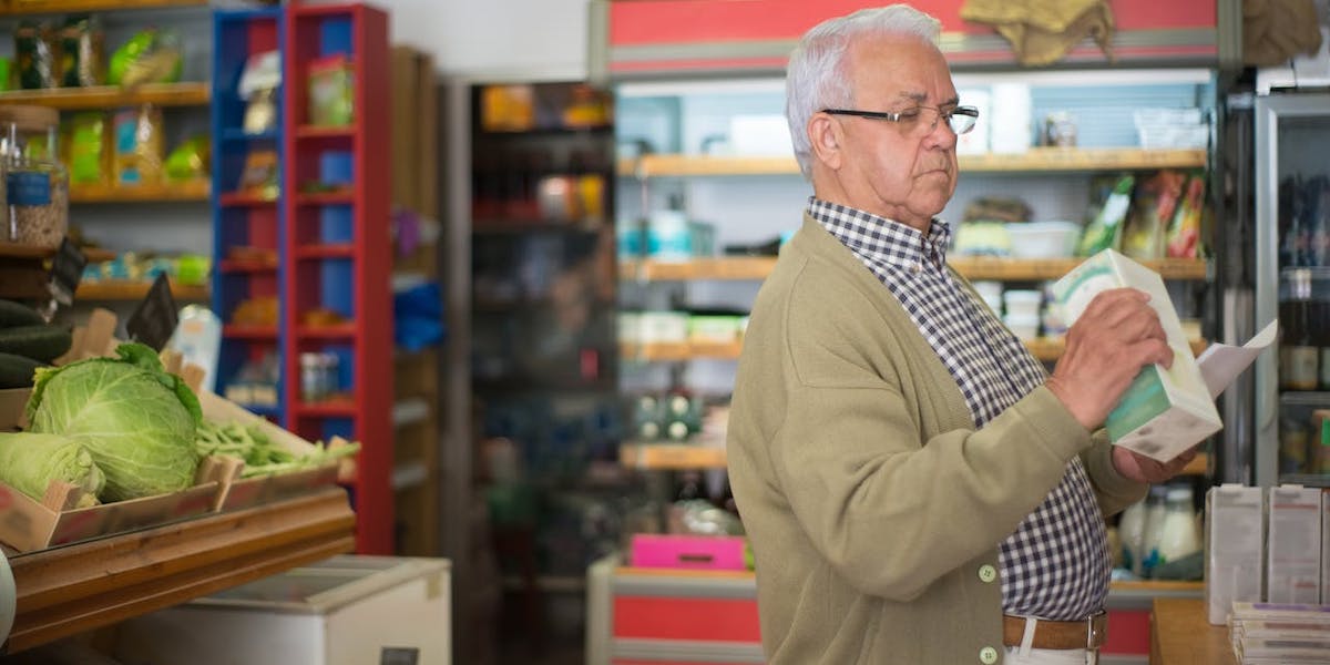 En man handlar mat. Pensionen räcker inte och många pensionärer behöver få ekonomiskt stöd från anhöriga.