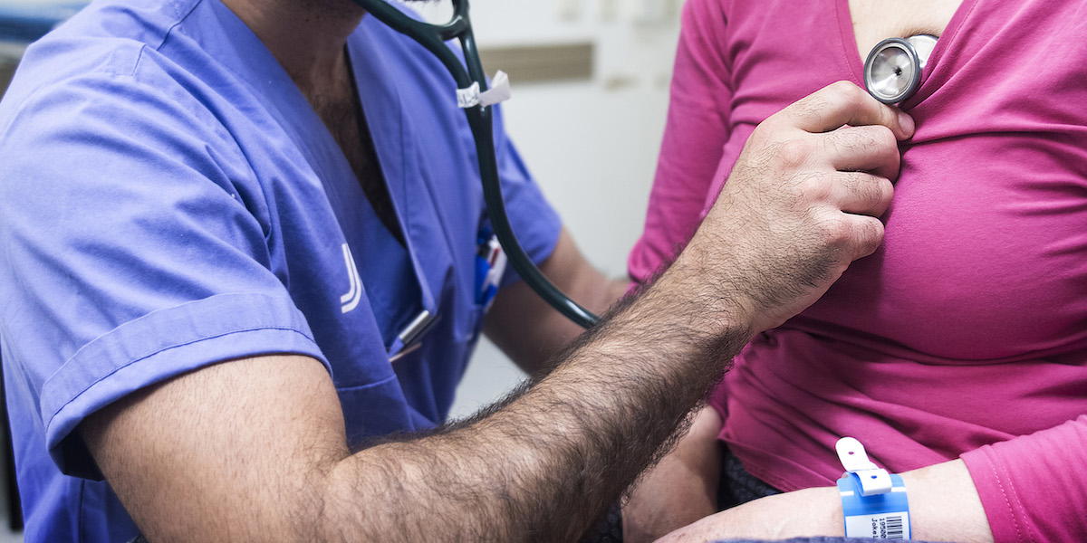 En läkare undersöker en patient med stetoskop. Antalet fall av allvarliga hjärtmuskelsjukdomar har ökat kraftigt i Sverige och överdödligheten är hög, särskilt bland yngre kvinnor.
