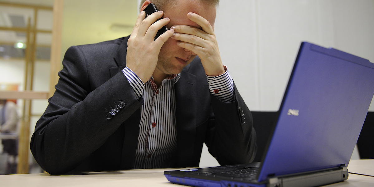 En bedrövad man pratar i en smartphone och tar sig för pannan. På bordet en bärbar dator. Det är vanligt med bedrägerier och många börjar med ett telefonsamtal. Bedragare riktar ofta in sig på äldre och vem som helst kan vli lurad, men det finns sätt att skydda sig.