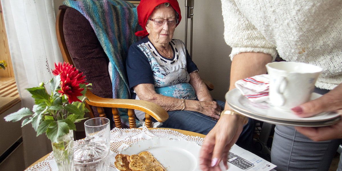 En äldre kvinna får hjälp att plocka bort disk. Regeringen har gett Socialstyrelsen i uppdrag att utveckla ett mått för att följa personalkontinuiteten i hemtjänst och särskilt boende.