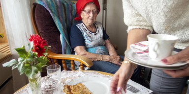 En äldre kvinna får hjälp att plocka bort disk. Regeringen har gett Socialstyrelsen i uppdrag att utveckla ett mått för att följa personalkontinuiteten i hemtjänst och särskilt boende.