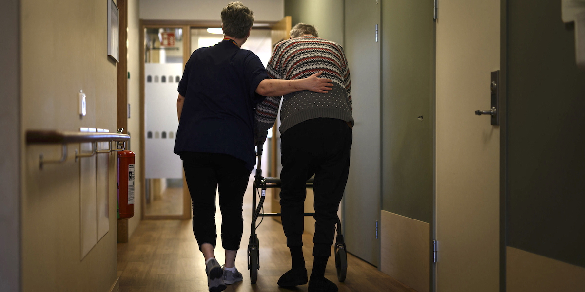 En person går med rullator med ett vårdbiträde bredvid på ett omsorgsboende för äldre. Färre av de allra äldsta har hemtjänst eller bor på äldreboenden. Medianåldern vid inflyttning till äldreboende är i dag drygt 86 år och den genomsnittliga boendetiden är drygt två år.