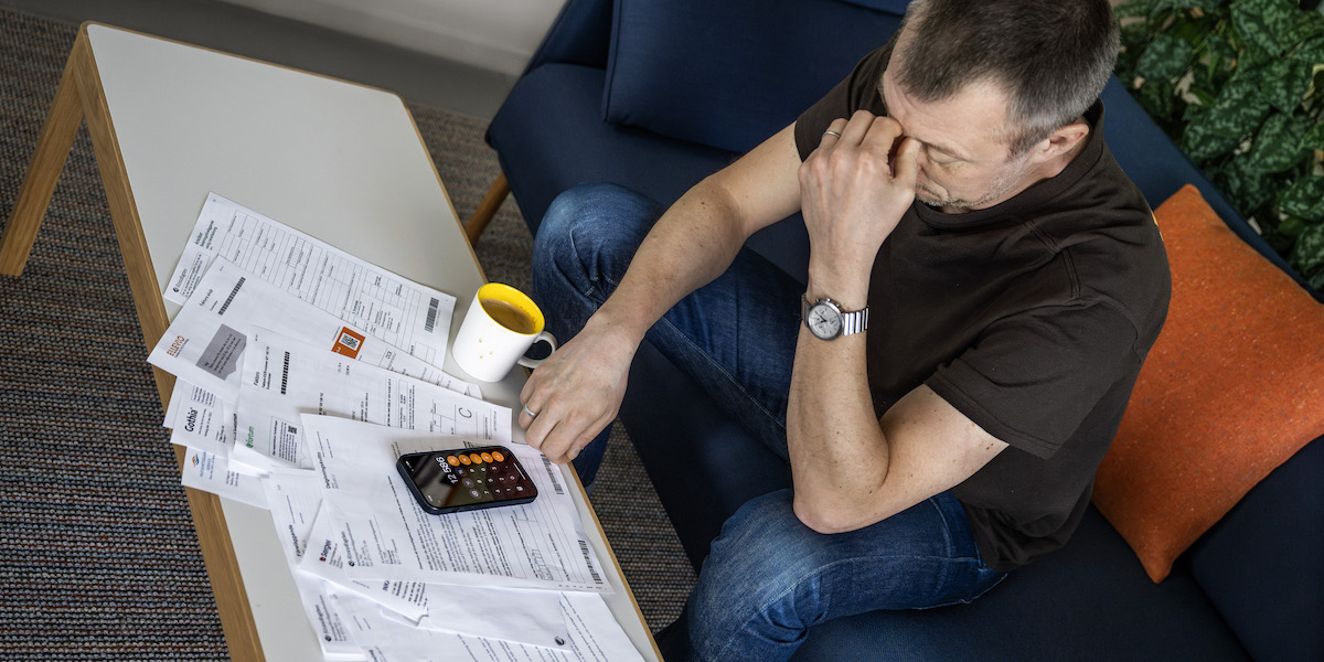 Bedrövad man med räkningar. Svenska hushålls skulder har nått den högsta årsnivå som någonsin uppmätts.