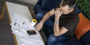 Bedrövad man med räkningar. Svenska hushålls skulder har nått den högsta årsnivå som någonsin uppmätts.