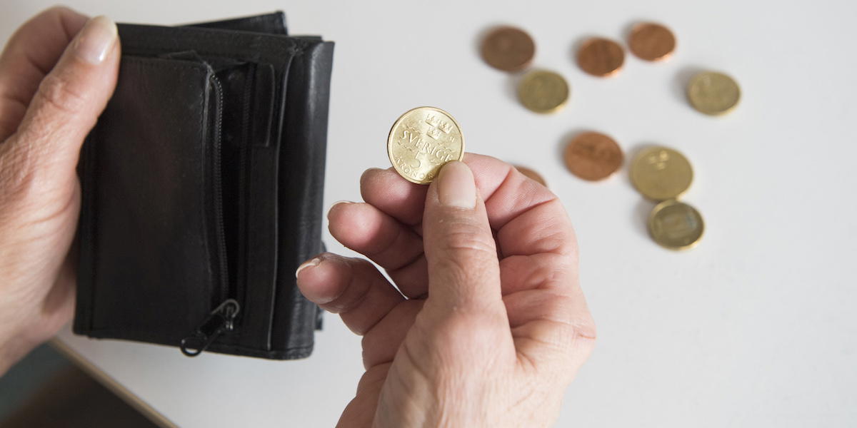 Pensionär med mynt och plånbok. En del pensionärer har fått mindre i plånboken i år.