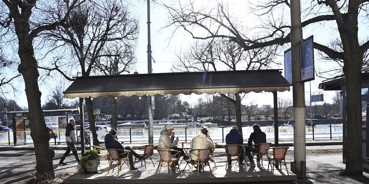 Människor sitter i vårsolen på en uteservering på Strandvägen. Efter den stränga vintern är våren här i stora delar av Sverige.