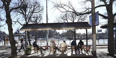 Människor sitter i vårsolen på en uteservering på Strandvägen. Efter den stränga vintern är våren här i stora delar av Sverige.