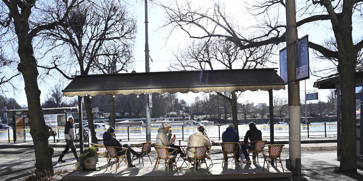 Människor sitter i vårsolen på en uteservering på Strandvägen. Efter den stränga vintern är våren här i stora delar av Sverige.