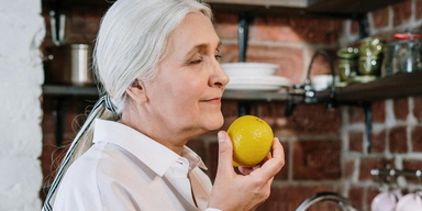 En kvinna luktar på en citron. Om du vill testa doftträning hemma ska du helst använda starka dofter, i forskning har dofter som citron, eukalyptus, kaffe och nejlika använts.