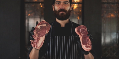 En man håller upp två köttbitar. För de flesta ger en växtbaserad kost lägre risk för demens, men en viss grupp människor får i stället lägre demensrisk av att äta mycket kött.