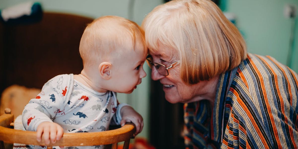 En baby och en pensionär. Lågt barnafödande ger låg pension.