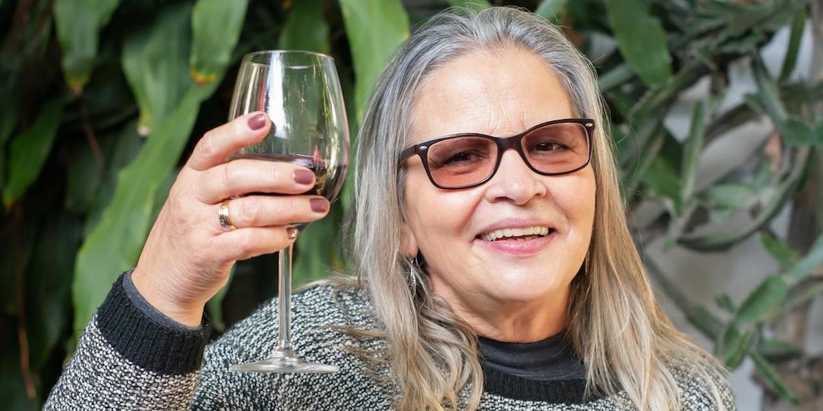 En kvinna skålar med ett glas vin. Alkohol kan påverka både klimakteriebesvär och pollenallergi genom att förvärra symtomen, här får du veta varför.