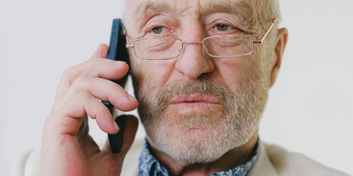 En man talar i telefon. Telefon- och sms-bedrägerier ökar och enligt Polisen har äldre en förhöjd risk att utsättas för brott som bedrägeri och stöld.