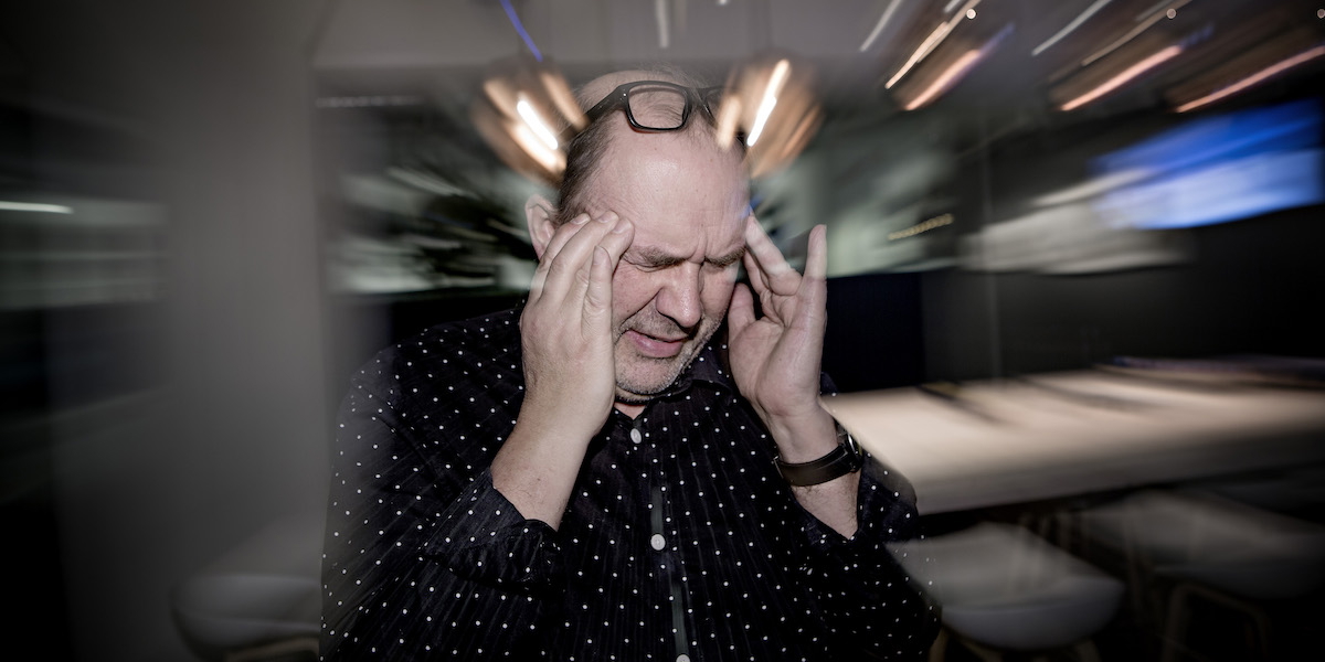 En man har huvudvärk.