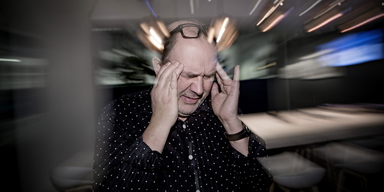 En man har huvudvärk.