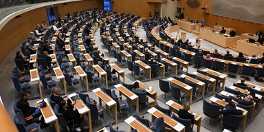 Översikt av riksdagens plenisal när Socialdemokraternas partiledare Magdalena Andersson(S) talar under partiledardebatten.