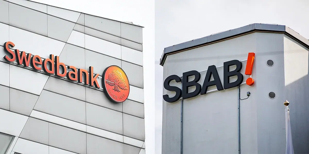 Swedbanks och SBAB:s loggor på fasader. Swedbank och SBAB har svarat på frågor om varför de inte sänker sina boräntor, trots att marknadsräntorna har fallit.