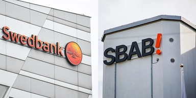 Swedbanks och SBAB:s loggor på fasader. Swedbank och SBAB har svarat på frågor om varför de inte sänker sina boräntor, trots att marknadsräntorna har fallit.