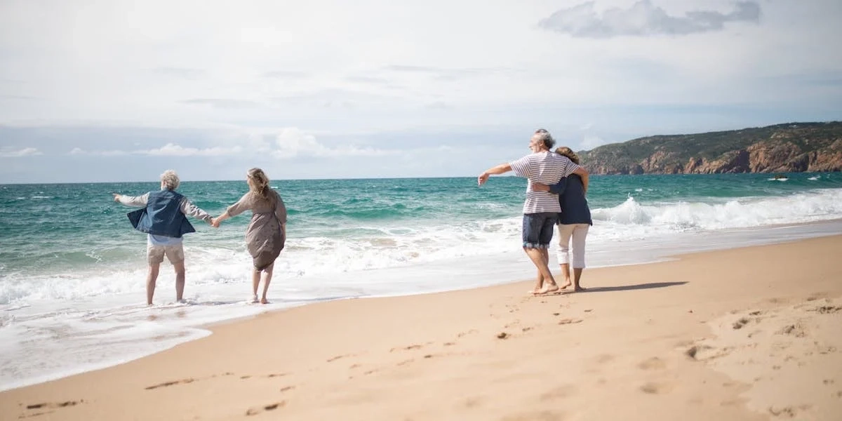 Två par på en sandstrand. En ny undersökning har tagit reda på hur mycket svenska hushåll planerar att spendera på resor och andra större aktiviteter i sommar, samt vad som oroar mest inför sommarsemestern.