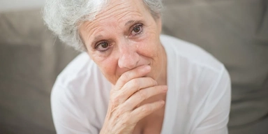 En ledsen kvinna funderar. Forskning har visat att det finns ett samband mellan tidig pensionering och kognitiv försämring, nu har ekonomer också hittat ett sådant orsakssamband.