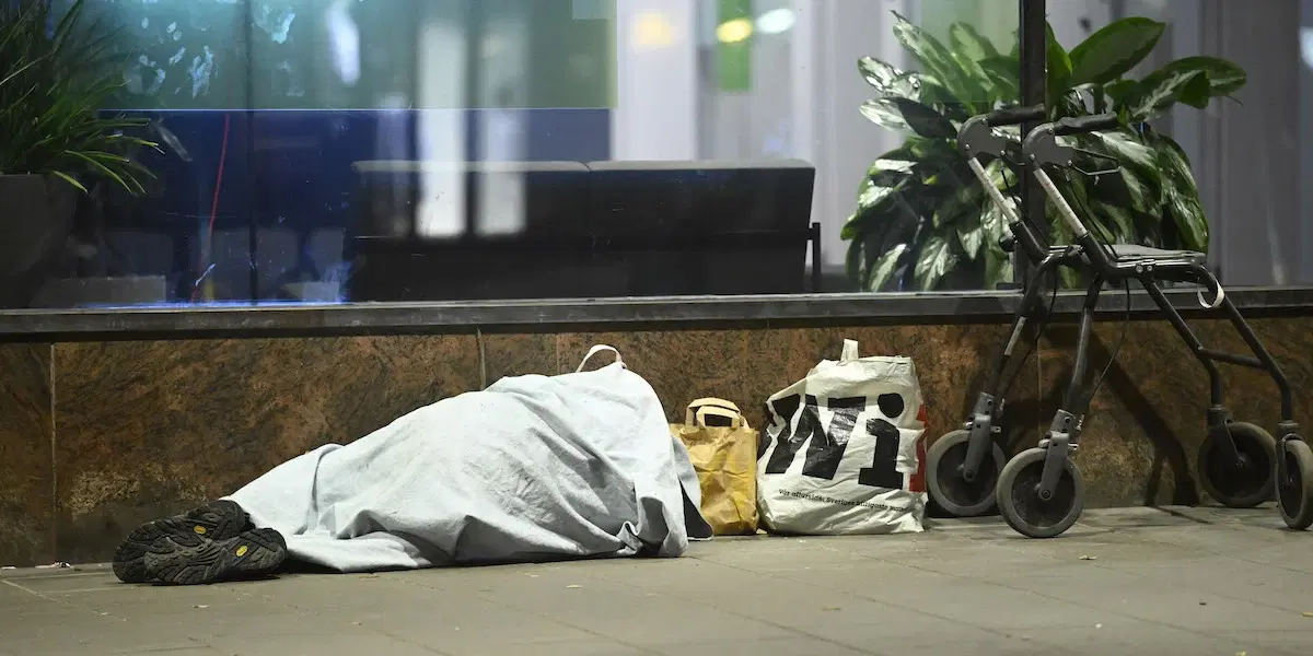 En uteliggare sover utanför ett bankkontor på på Sankt Eriksgatan i centrala Stockholm. en lagändring i folkbokföringslagen gör att hemlösa kan drabbas av att skrivas ut ur folkbokföringen och registreras som försvunna