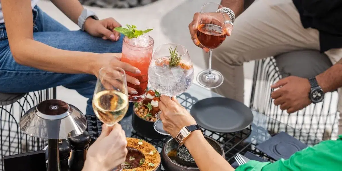 Månniskor skålar på en uteservering. Sådant som grillkvällar och uteserveringar bidrar till att svenskar dricker mer på sommaren. Här får du tips på hur du kan bryta sommarvanor som gör att du dricker mer än du vill.