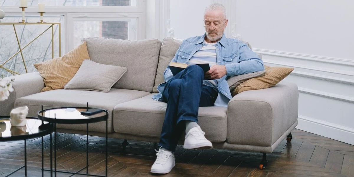 En man läser en bok. Den legitimerade psykologen och psykoterapeuten, Åsa Kruse, har skrivit en bok med praktiska tips och strategier om hur du får vardagen att fungera som pensionär.