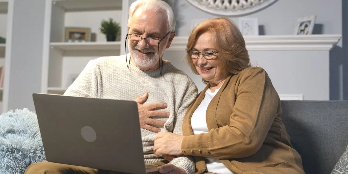ett par sitter i soffan och tittar på en datorskärm. Enligt en ny undersökning spenderar svenskar i genomsnitt 7 timmar och 38 minuter i veckan på att streama tv-serier och filmer.