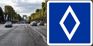 En väg i Paris och ett blått vägmärke med en vit romb.