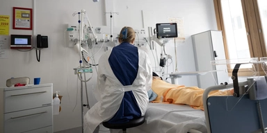 en sjuksköterska vid en patients sjuksäng på ett sjukhus. Sverige har byggt ett system som är bra på att behandla sjukdom, men sämre på att hjälpa människor att förbli friska.