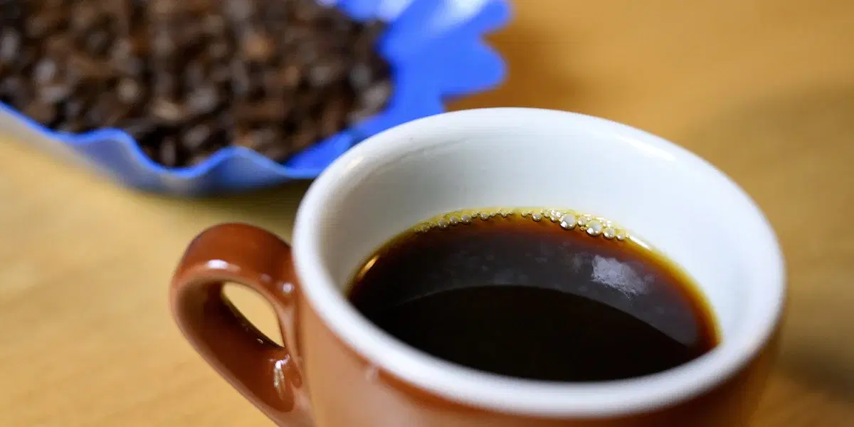 En kopp kaffe och kaffebönor.