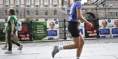 Valaffischer för Miljöpartiet, Moderaterna och Vänsterpartiet framför riksdagshuset i Stockholm inför riksdagsvalet 2026.